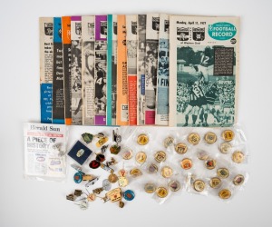 Group of thirteen 1977 Football Record issues spanning April 11 to August 6, together with twenty-six c. 1990s pin badges (teams comprise Cats, Kangaroos, Bulldogs, Hawks, Demons, Swans, and Blues), plus one other. (40 items)