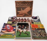 Group comprising a 33 x 33cm Essendon Bombers copper plaque, two late 1980s 40 x 62cm Essendon team photo posters (one signed by Terry Daniher and Kevin Sheedy), a folio of twenty-five early 1990s 30 x 20cm photographs of players on-field, ten club patche
