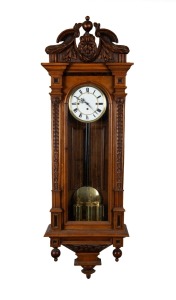 An antique Vienna regulator wall clock in carved walnut case, three train weight driven movement with Roman numerals, 19th century, 133cm high.