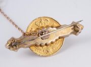 An 1835 English 22ct gold sovereign mounted as a brooch on a 9ct gold bar flanked by green stones, 19th century, 4.5cm wide, 12.8 grams total. - 2