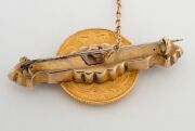 An 1835 English 22ct gold sovereign mounted as a brooch on a 9ct gold bar flanked by green stones, 19th century, 4.5cm wide, 12.8 grams total. - 3