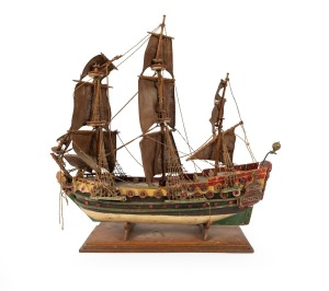 A scratch-built model galleon with hand-painted finish, in shipwreck condition, mid 20th century, 52cm high, 56cm long.