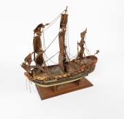 A scratch-built model galleon with hand-painted finish, in shipwreck condition, mid 20th century, 52cm high, 56cm long. - 2