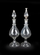 A pair of antique Whitehall Tatum crystal carboys, facetted and thumb cut decoration with unusual double stopper tops, 19th century, A/F, 76cm high.