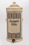 BERKEFELD antique German pottery water filter with burgundy and blue geometric decoration, early 20th century, 55cm high.