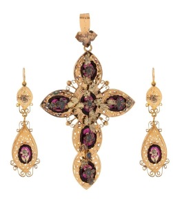 A stunning antique high carat yellow gold cross pendant and matching earrings adorned with two-tone gold florets, set in carbuncle garnets, housed in original leather case with blue silk interior, circa 1860, ​​​​​​​the cross an impressive 9cm high, 19 grams total