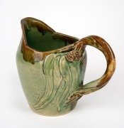 REMUED early green glazed pottery jug with experimental applied gumnuts, leaves and branch handle, incised "Remued, 1933", 18cm high.