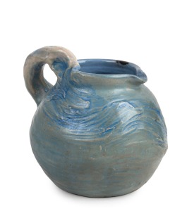 PHILIPPA JAMES blue glazed pottery jug with windswept tree decoration, incised "Philippa James", 17cm high.
