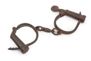 Antique adjustable handcuffs with original screw key and broad arrow mark, 19th century, 25cm wide.