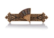 A fine quality antique 15ct gold and black enamel brooch adorned with a fan, set with natural gold ore polished specimens, 19th century, 6.5cm wide, 8.8 grams total.