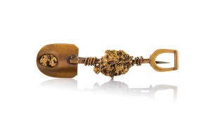 An antique 15ct gold miner's brooch in the form of a shovel with gold nugget specimens and entwined rope, 19th century, 5.1cm wide, 4.9 grams.