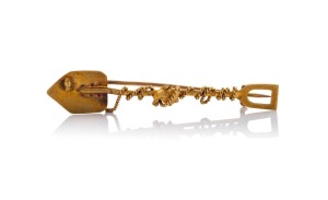 An antique 15ct gold miner's brooch of shovel form with gold nugget specimens and entwined rope, 19th/20th century, 5.8cm wide, 3.5 grams.