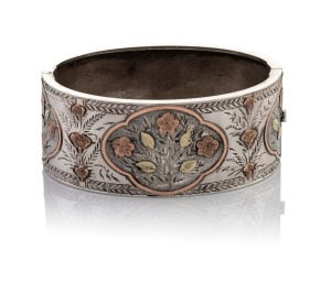An antique sterling silver bangle adorned with applied floral decoration in yellow and rose gold, 19th century, 6.5cm wide, internal 5.5cm wide, 31 grams total.