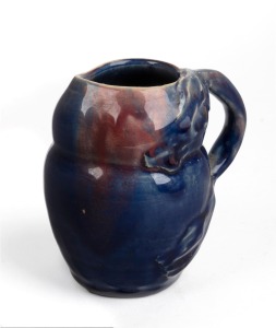 REMUED miniature pottery jug with applied windswept tree handle, glazed in blue and pink, 9.5cm high.