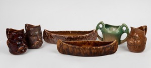 BENDIGO POTTERY face jugs; together with canoe troughs and a two handled vase, (6 items), the canoe 32cm long.