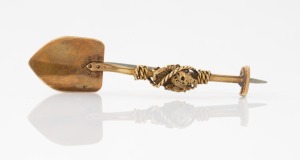 An antique 15ct gold miner's brooch in shovel form with nugget and entwined rope, 19th/20th century, 4.7cm wide, 3.2 grams.