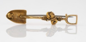 An antique 15ct gold miner's brooch in shovel form with nugget and entwined rope, 19th/20th century, 5cm wide, 4.5 grams.