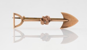 An antique 9ct rose gold miner's brooch of shovel form with nugget decoration, 19th/20th century, 4.7cm wide, 2.3 grams.