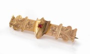 WILLIS & SONS of Melbourne antique Australian 9ct gold brooch with shield and red stone decoration, 19th/20th century, ​​​​​​​4.6cm wide, 2.3 grams.