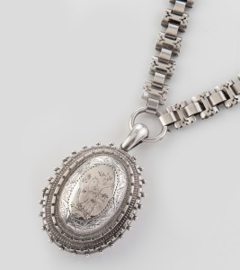 An antique English sterling silver locket engraved with bird decoration, suspended on an attractive matching chain with engraved links, made in Birmingham, circa 1881, the chain 40cm long, 38 grams total.