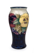 MOORCROFT "Pansy" pottery vase on blue and cream ground, underglazed green signature mark to base, and impressed "Moorcroft, Made In England", ​​​​​​​27cm high.