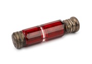 An antique faceted ruby glass double-ended scent bottle with silver tops, 19th century, ​​​​​​​10cm long.