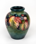 MOORCROFT "Leaves & Berries" pottery vase on green ground, impressed signature mark to base, 11cm high.