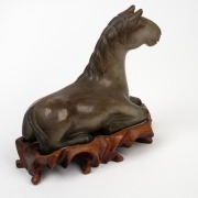 A Chinese carved jade horse statue on wooden stand, 20th century, ​​​​​​​13cm high, 15cm long overall. - 2