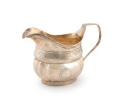 An antique sterling silver milk jug with bright cut decoration, most likely Channel Islands (marks rubbed), early 19th century, 11cm high, 16cm wide, 150 grams.