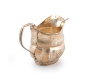An antique sterling silver milk jug with bright cut decoration, most likely Channel Islands (marks rubbed), early 19th century, 11cm high, 16cm wide, 150 grams. - 2