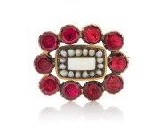 An antique 15ct gold brooch, set with a solid polished opal, surrounded by seed pearls and red stones, early to mid 19th century, 2.5cm wide, 4.8 grams total.
