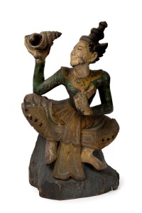 An antique Burmese carved wood and polychrome finished statue of a lady holding a conch shell, 19th/20th century, 49cm high.
