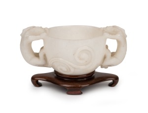 188 · An antique Chinese carved mutton jade cup on later carved timber stand, Ming Dynasty, 6cm high, 13.5cm wide, 8cm high on stand. PROVENANCE: The Rod Thomas Collection, Melbourne.