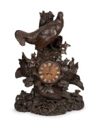 An antique German Black Forest carved timber mantle clock with game bird decoration, with period but replaced French eight day movement, 19th century,