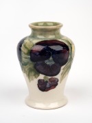 MOORCROFT "Pansy" miniature pottery vase on early celadon and cream ground, impressed "MOORCROFT, BURSLEM" with underglaze green signature "W. Moorcroft", 8.5cm high.
