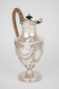 An antique English sterling silver water jug with woven cane insulated handle, made in Chester, circa 1903, ​​​​​​​23cm high, 352 grams total including handle and finial.