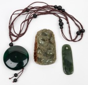 A New Zealand greenstone pendant, together with a Chinese jade and bead necklace on silk, and a Chinese carved jade dragon amulet, 19th/20th century, (3 items), the largest 6.2cm high.