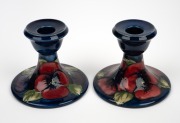 MOORCROFT "Pansy" pair of pottery candlesticks on blue ground impressed "MOORCROFT, MADE IN ENGLAND", 8cm high, 9.5cm diameter.