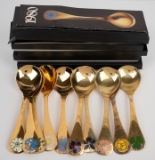 GEORG JENSEN group of ten Danish silver year spoons with gilt finish and enamel decoration, 15cm long, 450 grams total.