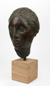 A museum replica bronze head, mounted on sandstone base, 83cm high.