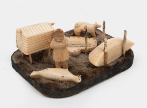 An Inuit art whalebone and seal fur carved ornament, signed "DWIGHT DILLIGROCK...", ​​​​​​​12cm wide.