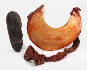 A carved kina shell breast plate ornament and clay totem, Papua New Guinea origin, 20th century, the shell 18cm wide.