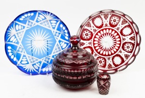 A Bohemian ruby overlay lidded glass jar; together with a similar fruit bowl, a miniature vase and a blue overlay glass fruit bowl, 20th century, (4 items), the largest 29cm diameter.