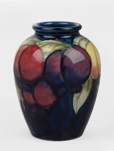 MOORCROFT "Wisteria" pattern pottery vase on blue ground, stamped "Moorcroft, Made In England", 11cm high.