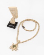 A vintage carved bone necklace with floral pendant, together with a carved ivory miniature profile bust of Nefertiti, 20th century, (2 items), the bust 6.5cm high.