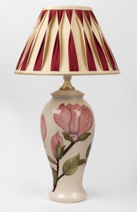 MOORCROFT "Magnolia" English pottery lamp base on cream ground, with vintage shade, 56cm high overall.