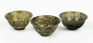 212 · Three Chinese spinach jade bowls, 19th/20th century, the largest 4.5cm high, 10cm diameter.
