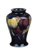 MOORCROFT "Wisteria" English pottery vase on blue ground with unusual floral decoration, impressed "Moorcroft, Made In England" 9cm high.