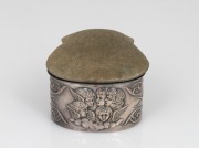 "CHORUS OF ANGELS" antique sterling silver dressing table box, interior fitted in original green plush silk, lid with pin cushion top, 19th century, 5cm high, 7cm wide, 7cm deep.