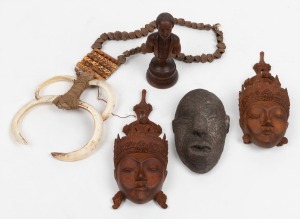 An antique carved wooden bust, early 19th century; together with a pair of carved wooden face masks, a reproduction Maori face mask and a Papua New Guinea tribal breast plate, (5 items), the bust 15.5cm high.